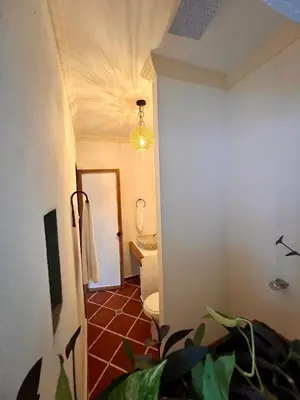 a hallway to a bathroom with a toilet and a light at Colonial Beach Airport Hotel in Cartagena de Indias