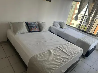 two twin beds in a room with a window at BARLOVENTO in Cartagena de Indias