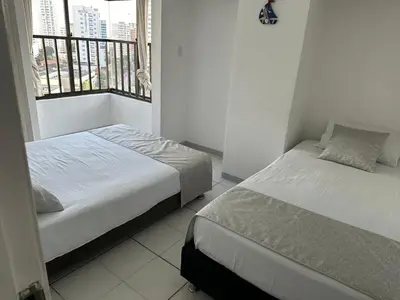 two beds in a small room with a window at BARLOVENTO in Cartagena de Indias