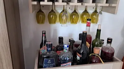a drawer filled with bottles of wine and wine glasses at Piantini Houses in Coveñas
