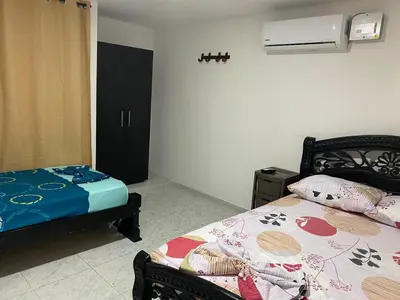 a bedroom with two beds in a room with a fan at Piantini Houses in Coveñas