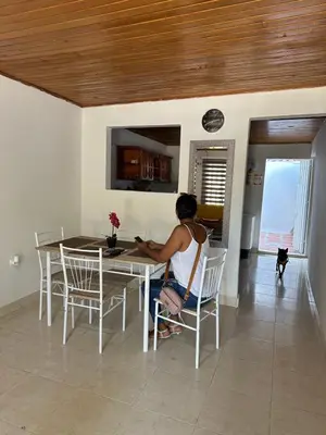 a woman sitting at a table in a kitchen at Casa Tamarielys 3 Habitaciones in Cartagena de Indias