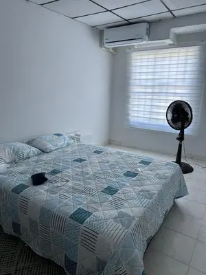 a bedroom with a bed and a window and a fan at Casa Tamarielys 3 Habitaciones in Cartagena de Indias