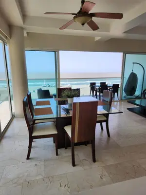 a dining room with a table and chairs and the ocean at Apartamento con terraza Frente al Mar in Cartagena de Indias