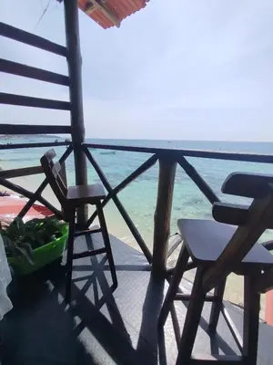 a balcony with two chairs and the ocean at Mi Cabañita Guest House in Playa Blanca