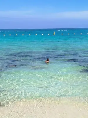 a person swimming in the ocean near a beach at Mi Cabañita Guest House in Playa Blanca