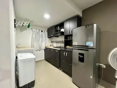 a kitchen with black cabinets and a stainless steel refrigerator at Tu lugar ideal cerca al mar apartamento MyM in Coveñas