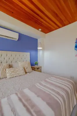a bedroom with a large bed with a blue wall at Amplia habitación con vista al mar y baño privado in Cartagena de Indias