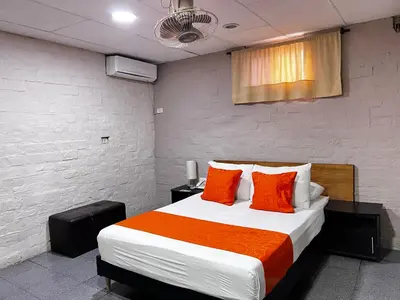 a bedroom with a bed with orange and white pillows at Hotel Casa Boston Inn by Finerh in Barranquilla