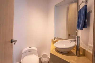 a bathroom with a white toilet and a sink at COMFORTABLE DEPARTAMENT IN FRONT THE SEA in Cartagena de Indias