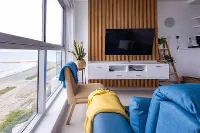 a living room with a television and a blue couch at COMFORTABLE DEPARTAMENT IN FRONT THE SEA in Cartagena de Indias
