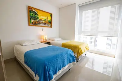 a bedroom with two beds and a window at COMFORTABLE DEPARTAMENT IN FRONT THE SEA in Cartagena de Indias