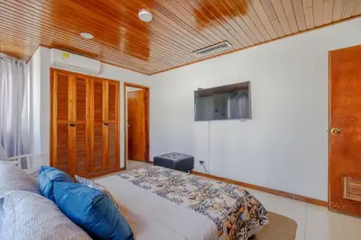 a bedroom with a bed and a flat screen tv at Habitación doble baño privado cerca al mar y bahia in Cartagena de Indias