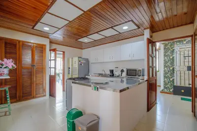 a large kitchen with white counter tops and wooden ceilings at Habitación doble baño privado cerca al mar y bahia in Cartagena de Indias