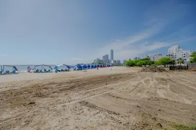 a sandy beach with buildings in the background at Habitación doble baño privado cerca al mar y bahia in Cartagena de Indias