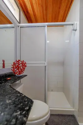 a bathroom with a toilet and a glass shower at Habitación para 3 a una cuadra de la playa y bahía in Cartagena de Indias