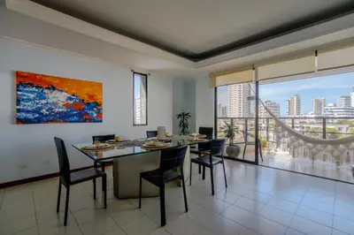 a dining room with a table and chairs and a large window at Habitación para 3 a una cuadra de la playa y bahía in Cartagena de Indias