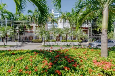 a palm tree in front of a building at Habitación para 3 a una cuadra de la playa y bahía in Cartagena de Indias
