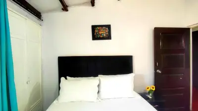 a bedroom with a bed with a black headboard and white pillows at Apartamento en Centro Histórico De Cartagena in Cartagena de Indias