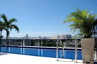 a swimming pool with palm trees on top of a building at Hotel Cartagena DC in Cartagena de Indias