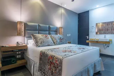 a bedroom with a large bed with a blue wall at Hotel Cartagena DC in Cartagena de Indias