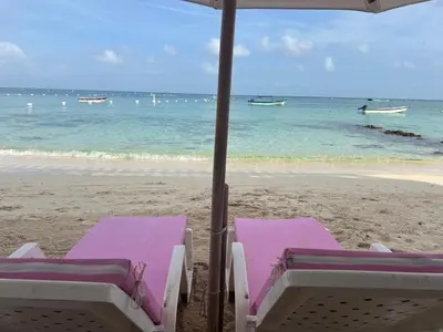 two lounge chairs and an umbrella on the beach at AcapulcoBeach in Playa Blanca