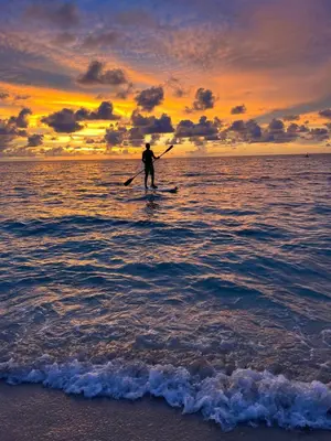 a man is standing on a surfboard in the ocean at AcapulcoBeach in Playa Blanca
