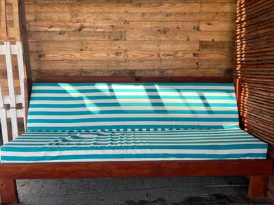 a wooden bench with a blue and white stripes at AcapulcoBeach in Playa Blanca
