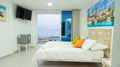a bedroom with a bed and a large window at CASA PLAYA JAMES in La Boquilla