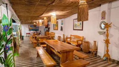 a restaurant with wooden tables and wooden chairs at CASA PLAYA JAMES in La Boquilla