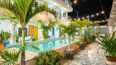 a large swimming pool with palm trees and plants at CASA PLAYA JAMES in La Boquilla