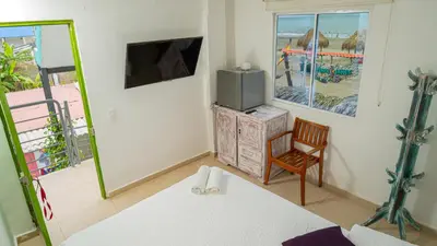 a room with a bed and a tv and a chair at CASA PLAYA JAMES in La Boquilla