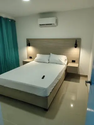 a bedroom with a large bed with white sheets at APARTAMENTOS LOS MANGLARES marbella in Cartagena de Indias