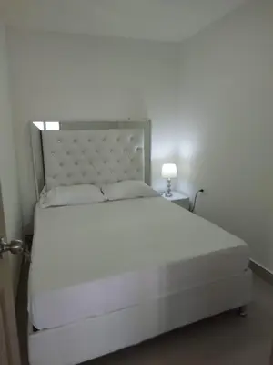 a bedroom with a white bed with a white headboard at APARTAMENTOS LOS MANGLARES marbella in Cartagena de Indias