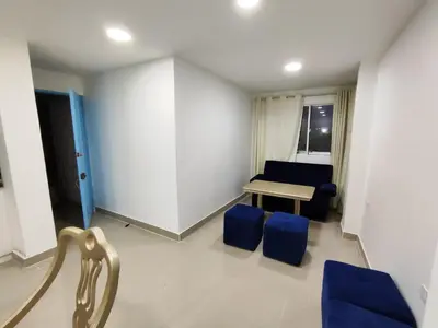 a living room with a table and blue chairs at APARTAMENTOS LOS MANGLARES marbella in Cartagena de Indias