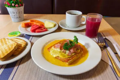 a table with plates of breakfast food and a cup of coffee at Azuán Suites Hotel By GEH Suites in Cartagena de Indias