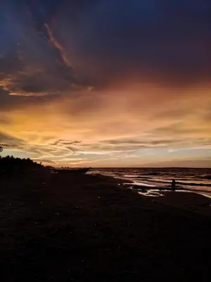 a person walking on the beach at sunset at Hostal torres del caribe in San Bernardo del Viento