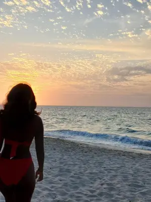 a woman standing on the beach looking at the ocean at Hugos Place Baru in Playa Blanca