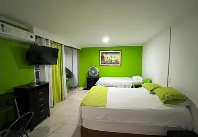 two beds in a room with green walls at El Conquistador in Cartagena de Indias