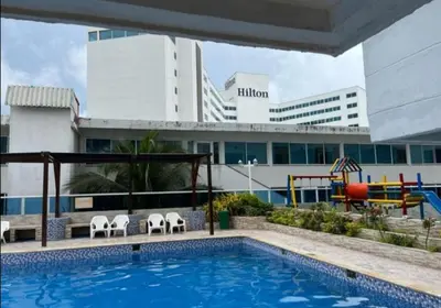 a pool with chairs and a playground in front of a building at El Conquistador in Cartagena de Indias