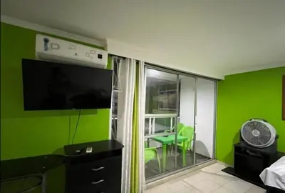 a room with green walls and a flat screen tv at El Conquistador in Cartagena de Indias