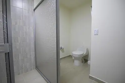 a bathroom with a toilet and a glass shower stall at Casa Bita Morales CASA 101 in Las Canoas