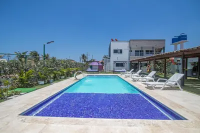 a swimming pool with lounge chairs next to a building at Casa Bita Morales CASA 101 in Las Canoas