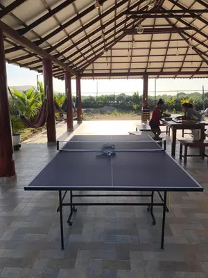 a ping pong table in a pavilion with people sitting at tables at Casa Bita Morales CASA 101 in Las Canoas