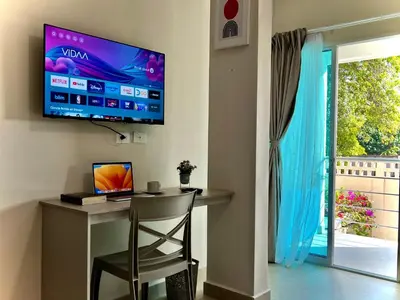 a desk with a chair and a television on a wall at Charme 64 Hotel Boutique in Cartagena de Indias