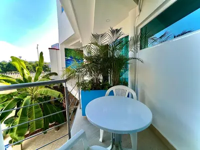 a white table and chairs on a balcony with a plant at Charme 64 Hotel Boutique in Cartagena de Indias