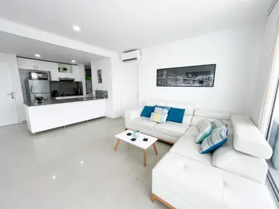 a white living room with a couch and a table at Apartamento Cartagena Morros Epic in Cartagena de Indias