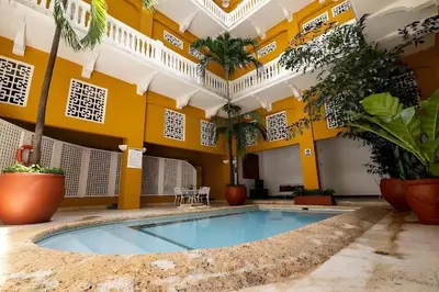a pool in the courtyard of a building with plants at Edificio Ayos dentro la ciudad amurallada in Cartagena de Indias