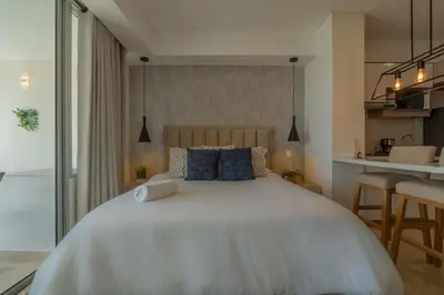 a bedroom with a large white bed with blue pillows at Condominio exclusivo nuevo frente al mar Cartagena Beach in Cartagena de Indias