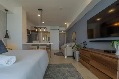 a bedroom with a large bed and a living room at Condominio exclusivo nuevo frente al mar Cartagena Beach in Cartagena de Indias